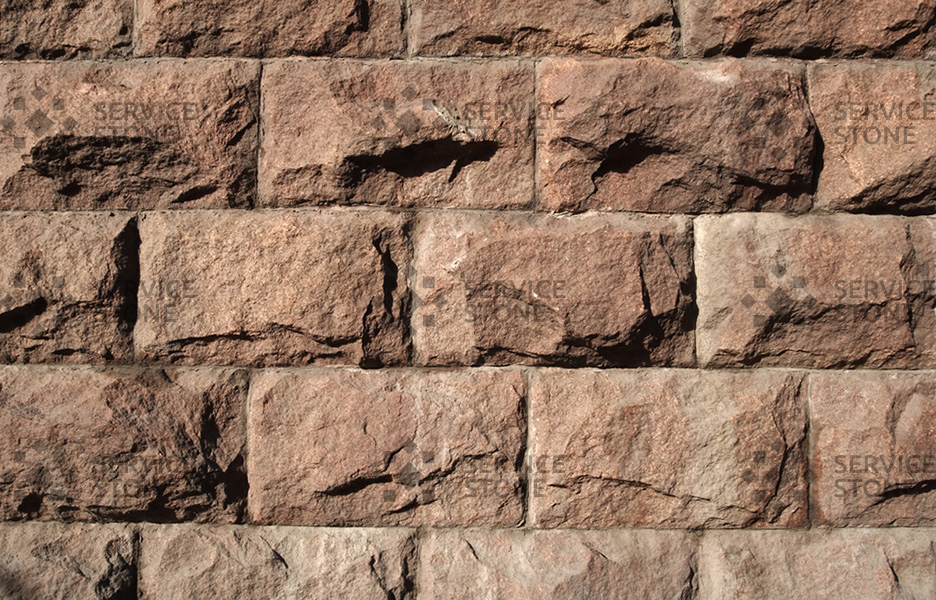 Стена здания, облицованная гранитным камнем Скала